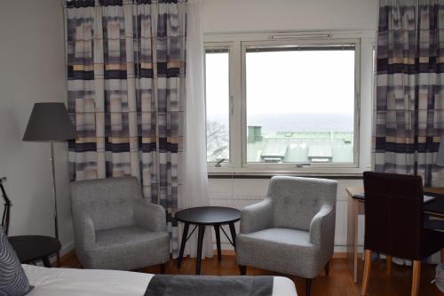 a bedroom with two chairs and a table and a window at Sure Hotel by Best Western City Jonkoping in Jönköping