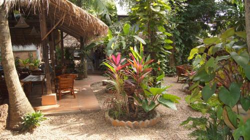 a garden with a table and chairs and plants at Mut Mee Garden Guest House in Nong Khai