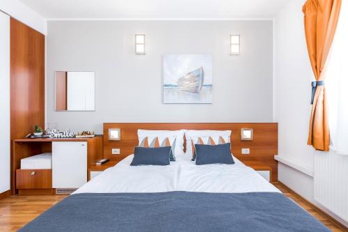 a bedroom with a large white bed with blue pillows at Villa Nada in Lovran
