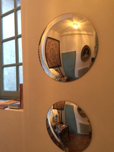 a mirror hanging on a wall in a room at Face au Palais in Avignon