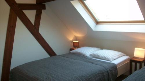 Schlafzimmer im Dachgeschoss mit einem Bett und einem Dachfenster in der Unterkunft 'tMaelhof in Voeren