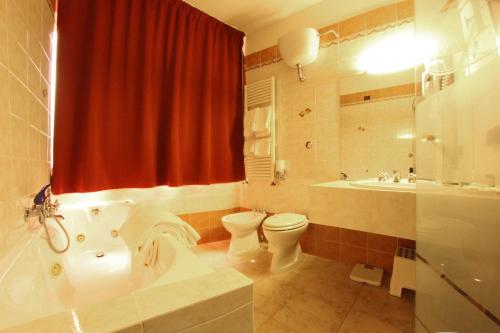 y baño con bañera, aseo y lavamanos. en Hotel Forum, en Foiano della Chiana