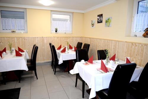 a dining room with white tables and red napkins at Hotel Neugrabener Hof in Hamburg