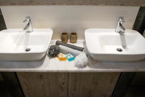 two white sinks on a counter in a bathroom at Sunset Apartments Free shuttle from Athen's Airport in Spáta