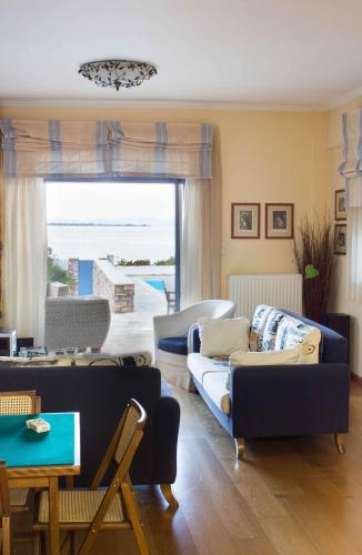 a living room with two couches and a table at Villa Blue Island in Artemida