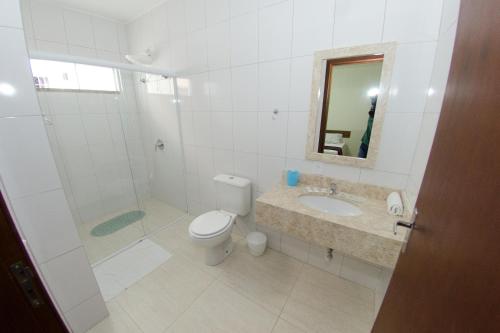 a bathroom with a toilet and a sink and a shower at Pousada Recanto dos Anjos in Penha