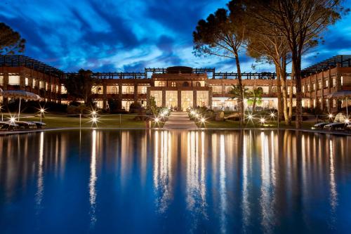 a building with a pond in front of it at night at La Villa Del Re - Adults Only - Small Luxury Hotels of the World in Castiadas