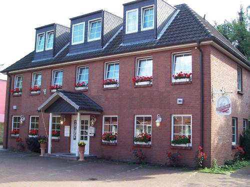 a red brick building with flower boxes on the windows at Hotel Neugrabener Hof in Hamburg