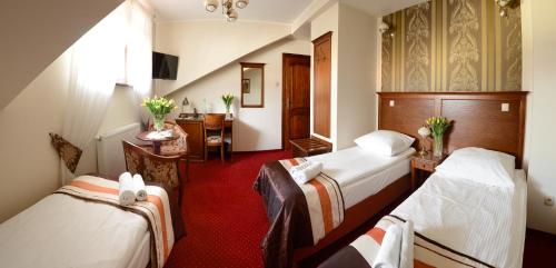 a hotel room with two beds and a desk at Dworek Vesaria in Lublin