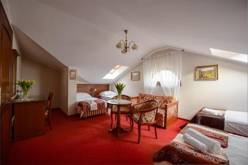 ルブリンにあるDworek Vesariaのベッドとテーブルが備わるホテルルームです。