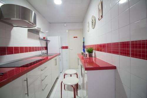 サロウにあるSan Remo Iberplayaの赤と白のキッチン(白のキャビネット、赤のタイル付)