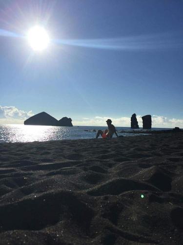 a group of people sitting on the beach at Casa Quinta das Férias in Ginetes