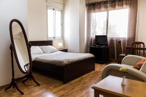 a bedroom with a bed and a mirror and a couch at Elysium Capital Residence in Nicosia