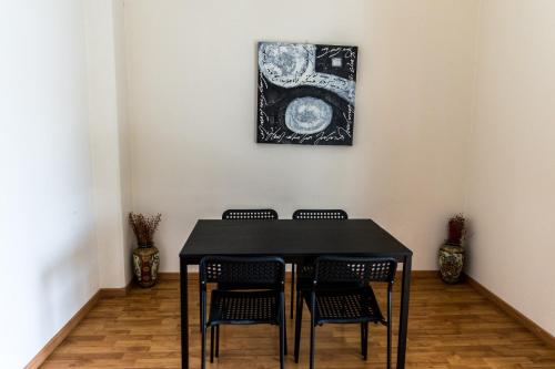 a black table with chairs and a picture on the wall at Elysium Capital Residence in Nicosia