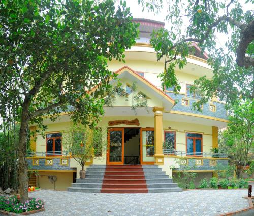 a yellow house with stairs in front of it at Hoang Giang Homestay in Ninh Binh