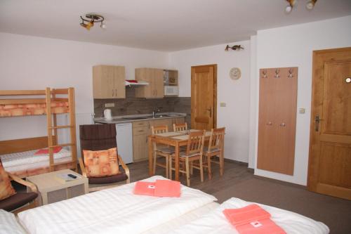 Zimmer mit 2 Betten und einer Küche mit einem Tisch in der Unterkunft OK-35 in Rokytnice nad Jizerou