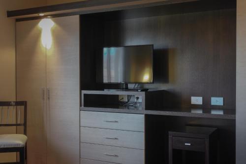 a room with a counter with a tv on the wall at Hotel Ankara Suites in Salta