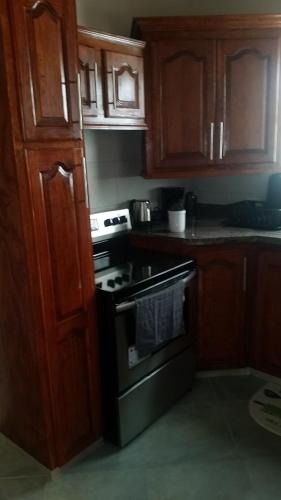 a kitchen with wooden cabinets and an oven at Frontline Apartments in Christ Church