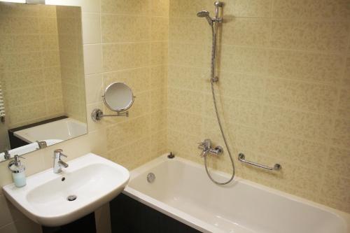 y baño con ducha, lavabo y bañera. en Velence Resort Apartman, en Velence