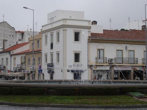 a white building next to a river with buildings at Alojamentos Casa Facha Papaia in Portalegre