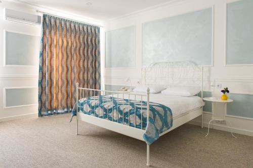 فندق تو سيزونز باكو البوتيكي في باكو: غرفة نوم بسرير ابيض ونافذة