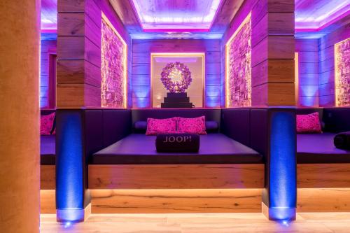 a room with purple walls and a bench with a box on it at Alpin Resort Sacher in Seefeld in Tirol