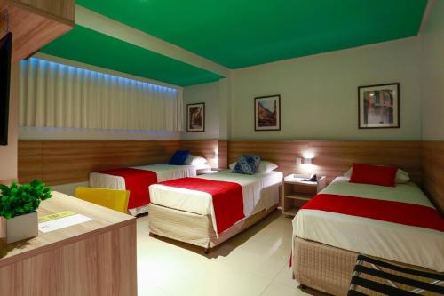a hotel room with two beds and a green ceiling at Portofino Hotel Prime in Teresina