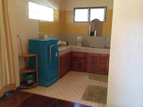 a kitchen with a blue refrigerator and a sink at Pimpa House พิมพาเฮาส์ in Ban Hua Nam Mae Sakut