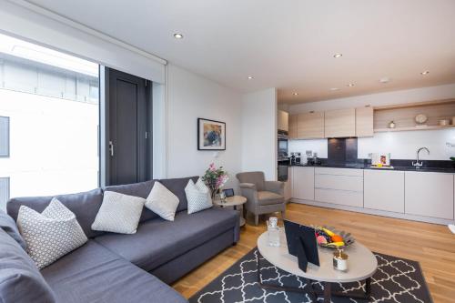 a living room with a couch and a table at Portobello Apt with Floor-to-Ceiling Views in London