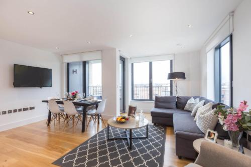 a living room with a couch and a table at Portobello Apt with Floor-to-Ceiling Views in London