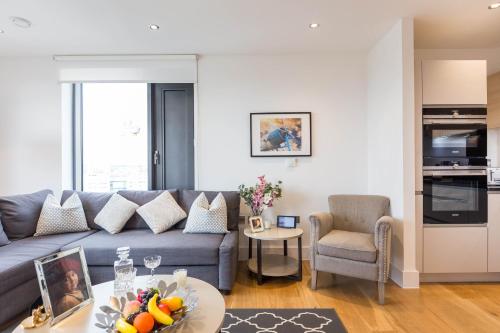 a living room with a couch and a table at Portobello Apt with Floor-to-Ceiling Views in London