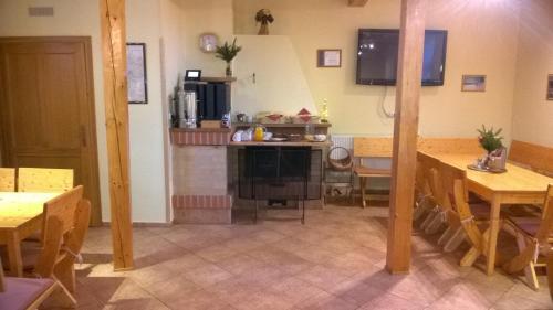 een eetkamer met tafels en een keuken met een aanrecht bij Penzion Pod Zvonem in Hynčice pod Sušinou