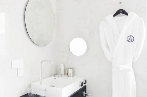 a white bathroom with a sink and a mirror at Perpetual Elysée Montaigne in Paris