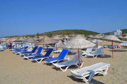 a row of chairs and umbrellas on a beach at Mulka Hotel in Ayvalık