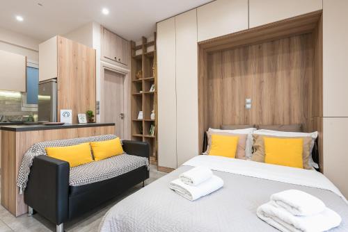 雅典的住宿－雅典中心設計公寓，一间卧室配有两张带黄色枕头和椅子的床