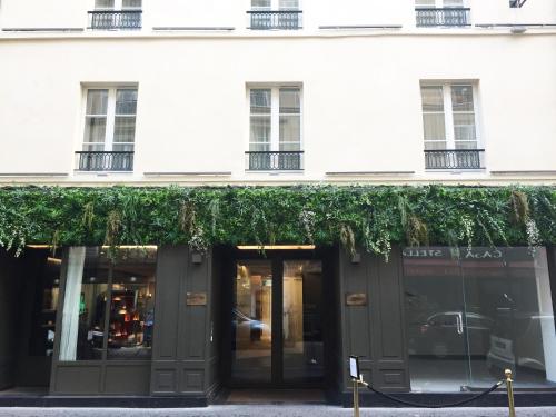 a store front of a white building with green ivy at Perpetual Elysée Montaigne in Paris