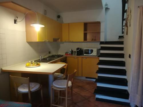 a kitchen with a staircase leading up to a kitchen with yellow cabinets at Casa Burrasca in Levanto