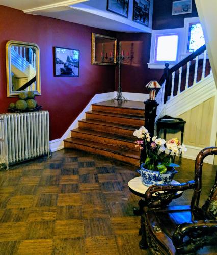 a living room with stairs and a vase of flowers at Chelsea Pub and Inn in Atlantic City