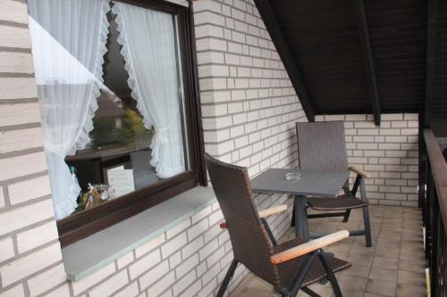 a table and two chairs on a balcony with a window at Haus Sigge Ferienwohnungen in Bad Sassendorf