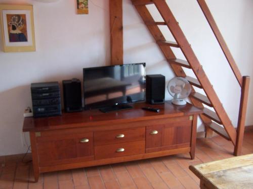 - une commode en bois avec une télévision et des haut-parleurs dans l'établissement Residence Lou Cigaloun, à La Croix-Valmer