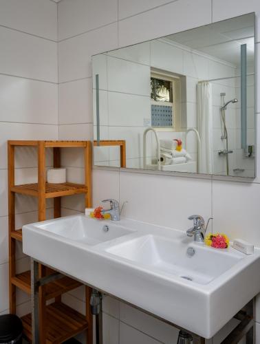 a bathroom with a white sink and a large mirror at Buddy Dive Resort in Kralendijk