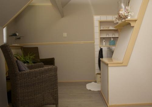 un salon avec un escalier, une chaise et une table dans l'établissement Lekker bij MaAs, à Dreischor