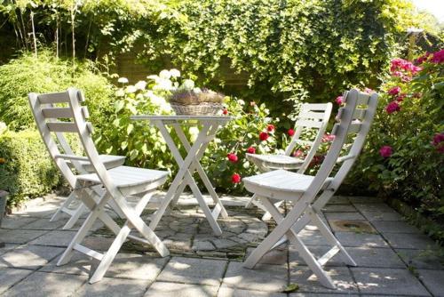 2 chaises et une table dans un jardin fleuri dans l'établissement Lekker bij MaAs, à Dreischor