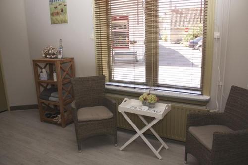 - un salon avec des chaises, une table et une fenêtre dans l'établissement Lekker bij MaAs, à Dreischor