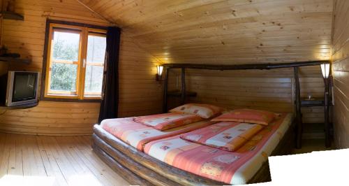 a bedroom with a bed in a wooden room at Rustic House in Stana de Vale