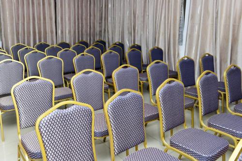 a row of chairs in a room with curtains at Hotel le Pelican in Lomé