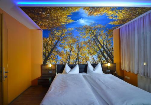 a bedroom with a bed with a large painting on the ceiling at Hotel Wandersleben - Erfurt in Wandersleben