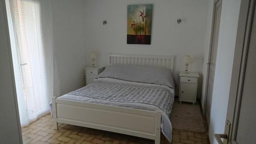 uma cama num quarto com duas mesas de cabeceira e um quadro na parede em Le Broussan em Évenos