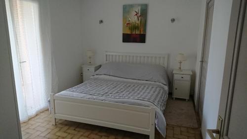 ÉvenosにあるLe Broussanのベッド1台、壁に絵画が備わるベッドルーム1室