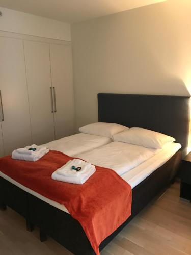 a bedroom with a bed with two towels on it at The Apartments Company - Aker Brygge in Oslo